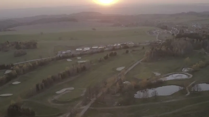 Letecký pohled na golfové hřiště a domy při západu slunce