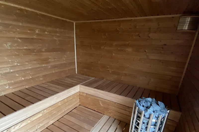 Dřevěná sauna s kamny v domě první etapy